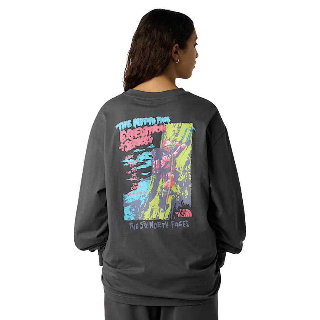 Modelo mostrando la parte trasera de la camiseta The North Face Expedition Celebration anthracite grey, con estampado gráfico de montaña.