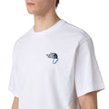 Detalle del logo The North Face y pequeño mosquetón azul en el pecho de la camiseta Explore Carabiner Relaxed Tee blanca.