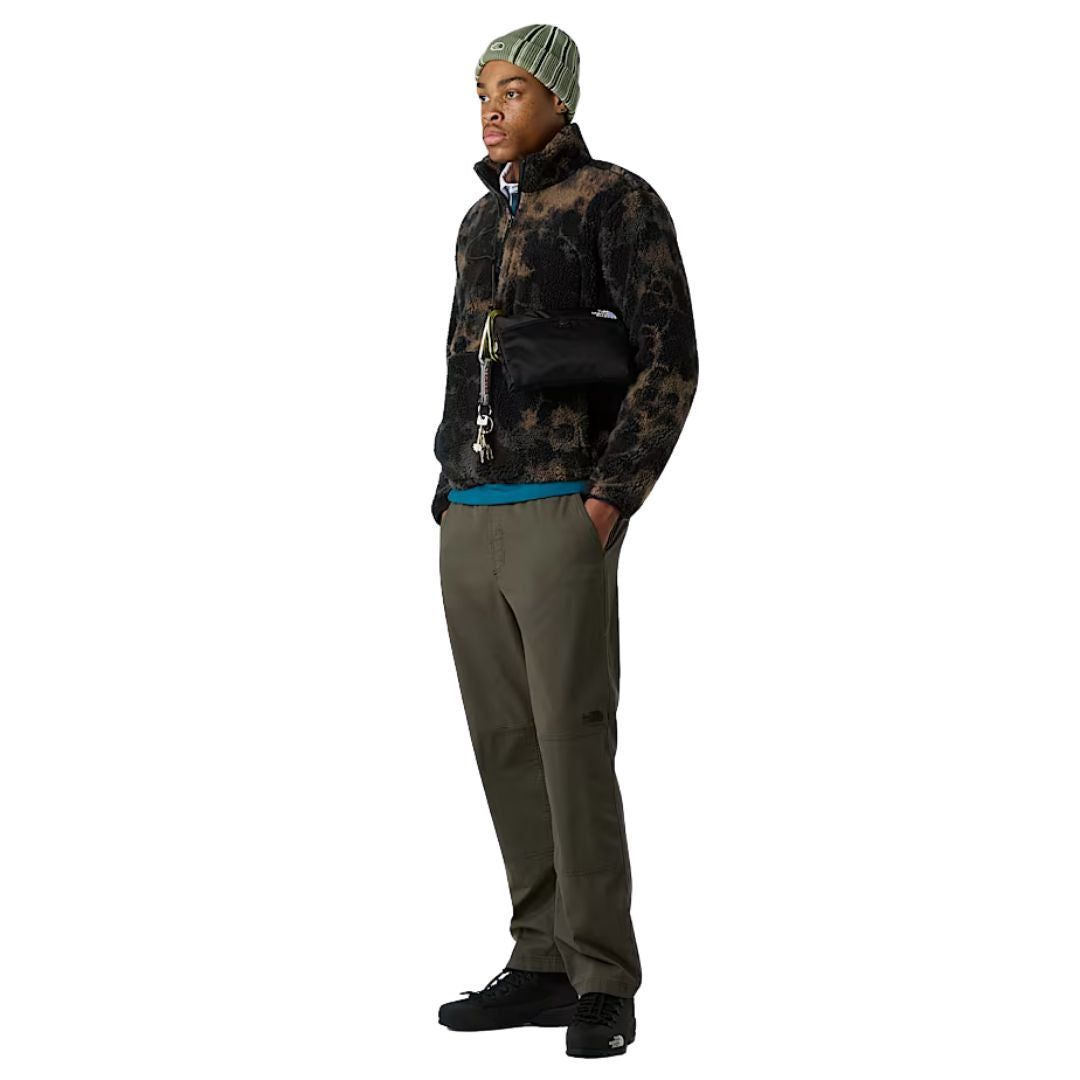Modelo de cuerpo entero vistiendo la chaqueta The North Face Extreme Pile 2 Jacket TNF Black Light Refractions Print combinada con pantalón verde y gorro.