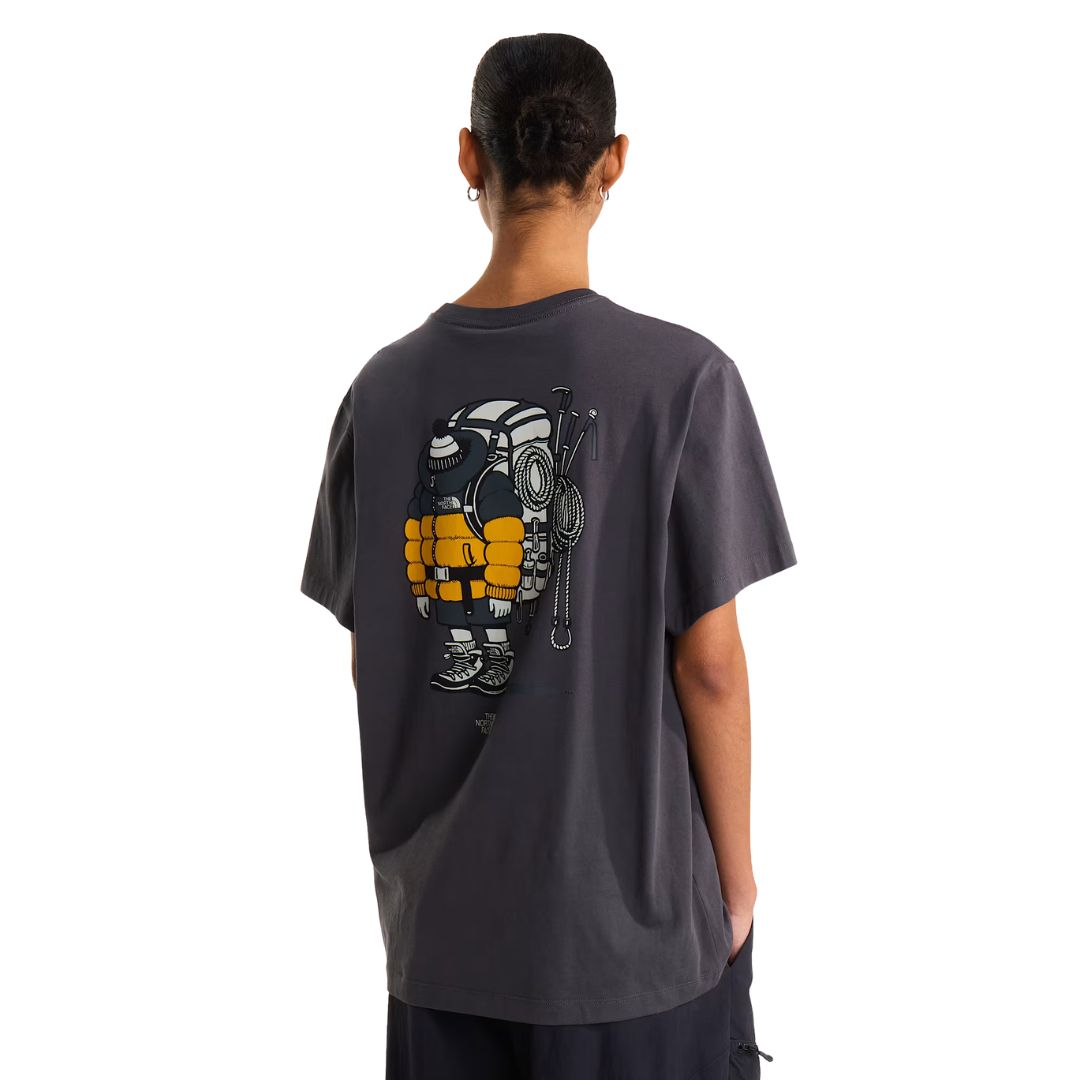 Camiseta The North Face Gear Up Get Out RLX en gris antracita puesta en modelo mujer, vista de espalda mostrando el gráfico completo del mochilero con mochila amarilla, cuerdas y piolets.