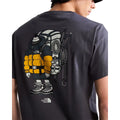 Camiseta The North Face Gear Up Get Out RLX en gris antracita puesta en modelo hombre, primer plano de la espalda mostrando en detalle el gráfico del mochilero con mochila amarilla, cuerdas y piolets.