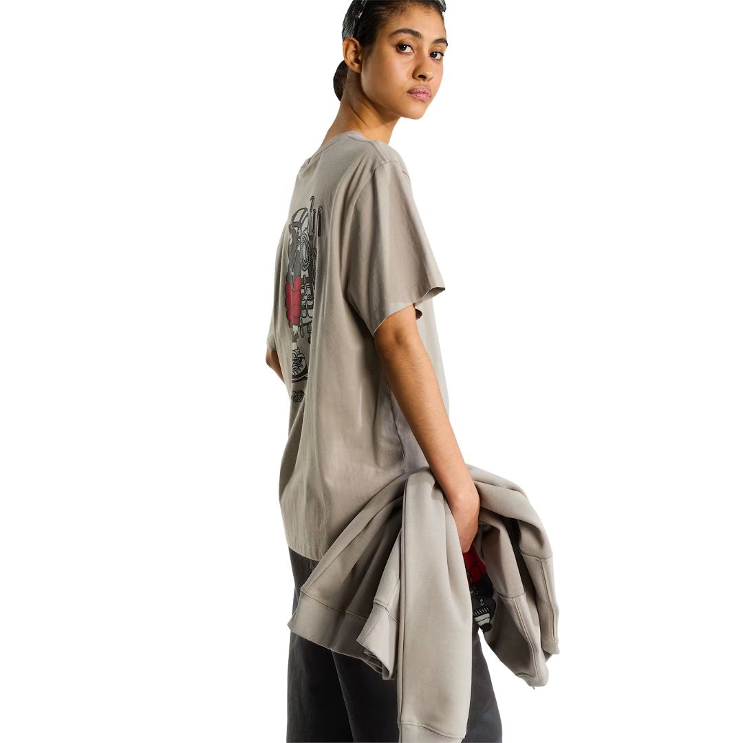 Camiseta The North Face Gear Up Get Out RLX en color piedra puesta en modelo mujer, vista lateral de perfil con sudadera a juego en la mano, luciendo parcialmente el gráfico trasero.
