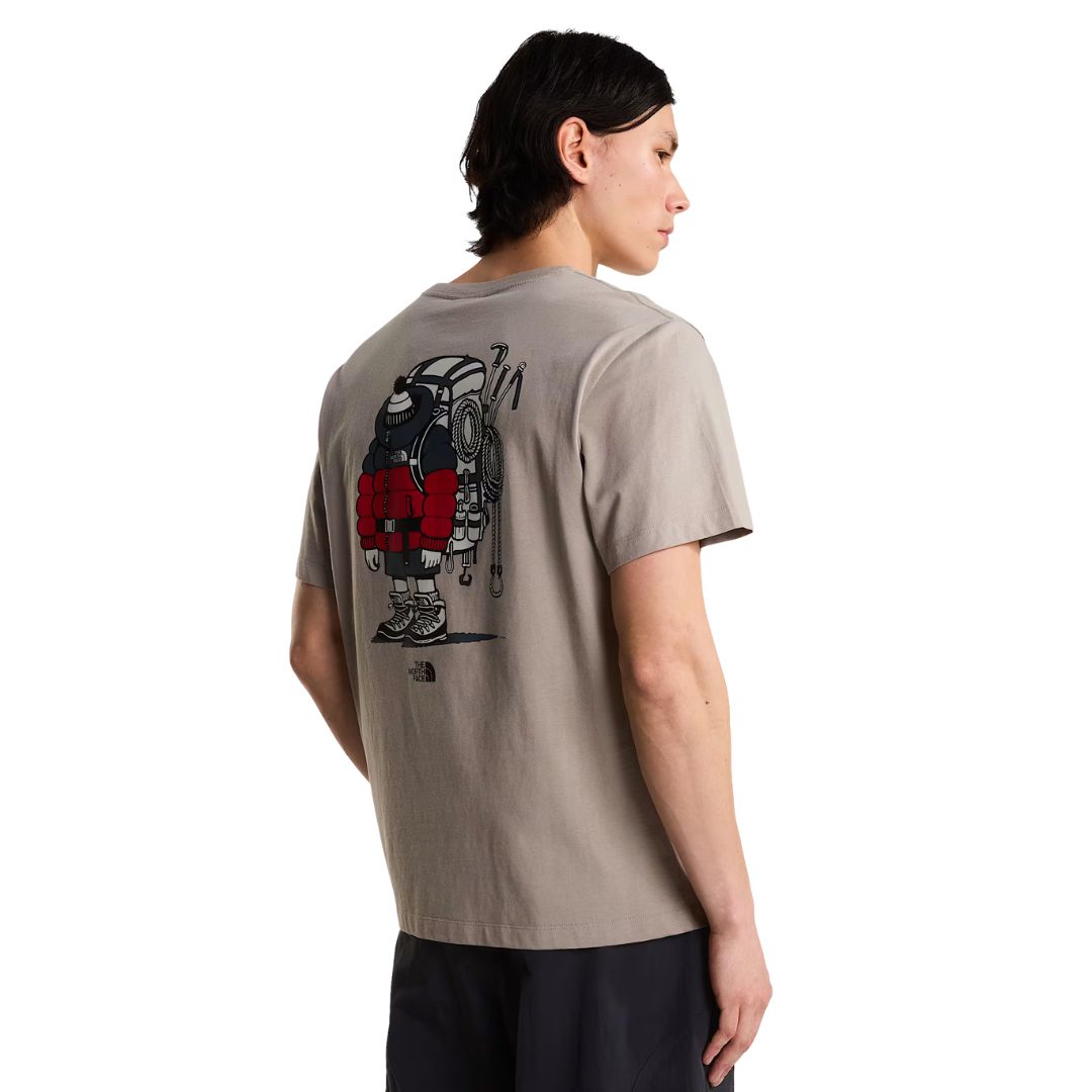 Camiseta The North Face Gear Up Get Out RLX en color piedra puesta en modelo hombre, vista de espalda mostrando el gráfico completo del mochilero cargado con mochila roja, cuerdas y piolets.