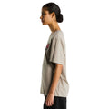 Camiseta The North Face Gear Up Get Out RLX en color piedra puesta en modelo mujer, vista lateral de perfil mostrando el gráfico pequeño del mochilero con logo rojo en el pecho.