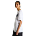 Camiseta The North Face Gear Up Get Out RLX en blanco puesta en modelo mujer, vista lateral de perfil mostrando el gráfico pequeño del mochilero en el pecho.