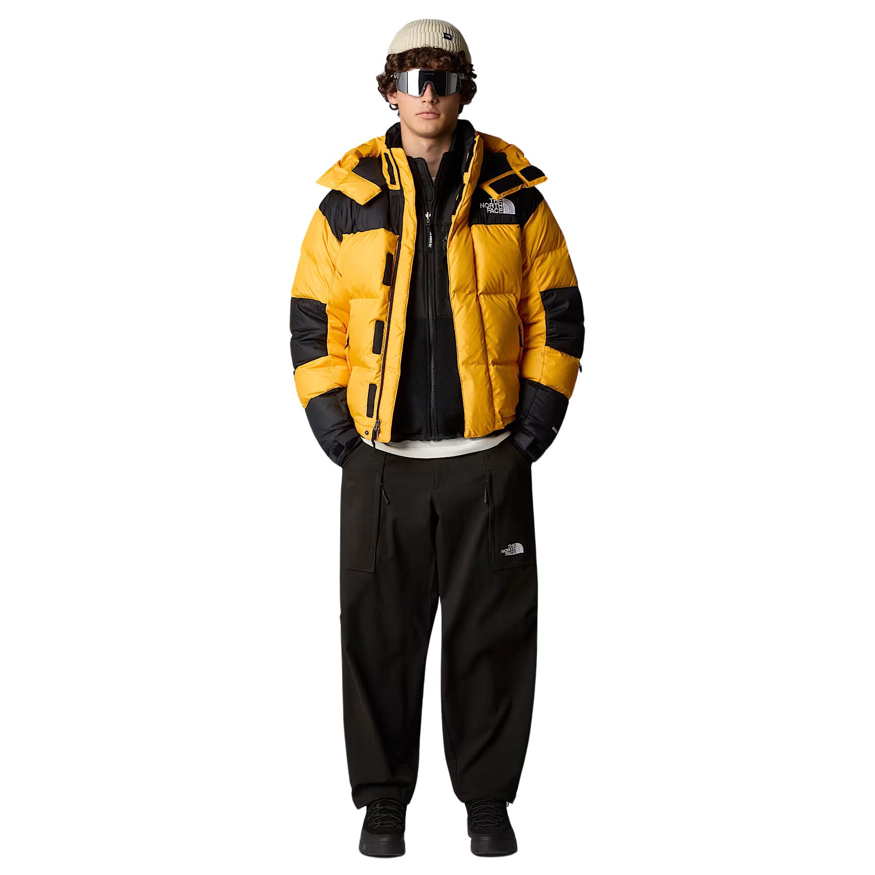 Hombre con Chaqueta The North Face HMLYN Baltoro Amarilla, gorro y gafas de sol