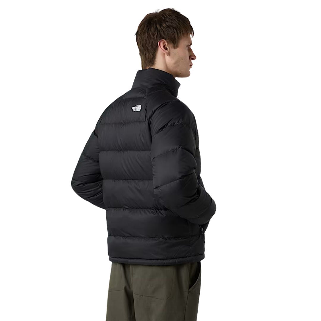 Modelo masculino vistiendo la chaqueta The North Face Hydrenalite Down negra, vista lateral trasera.