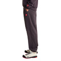 Vista lateral en modelo del pantalón de chándal Red Box de The North Face en color Obsidian, mostrando el bolsillo lateral con el parche bordado Red Box y el corte relajado.