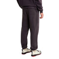 Vista trasera en modelo del pantalón de chándal Red Box de The North Face en color Obsidian, combinado con sudadera a juego y zapatillas de senderismo The North Face.
