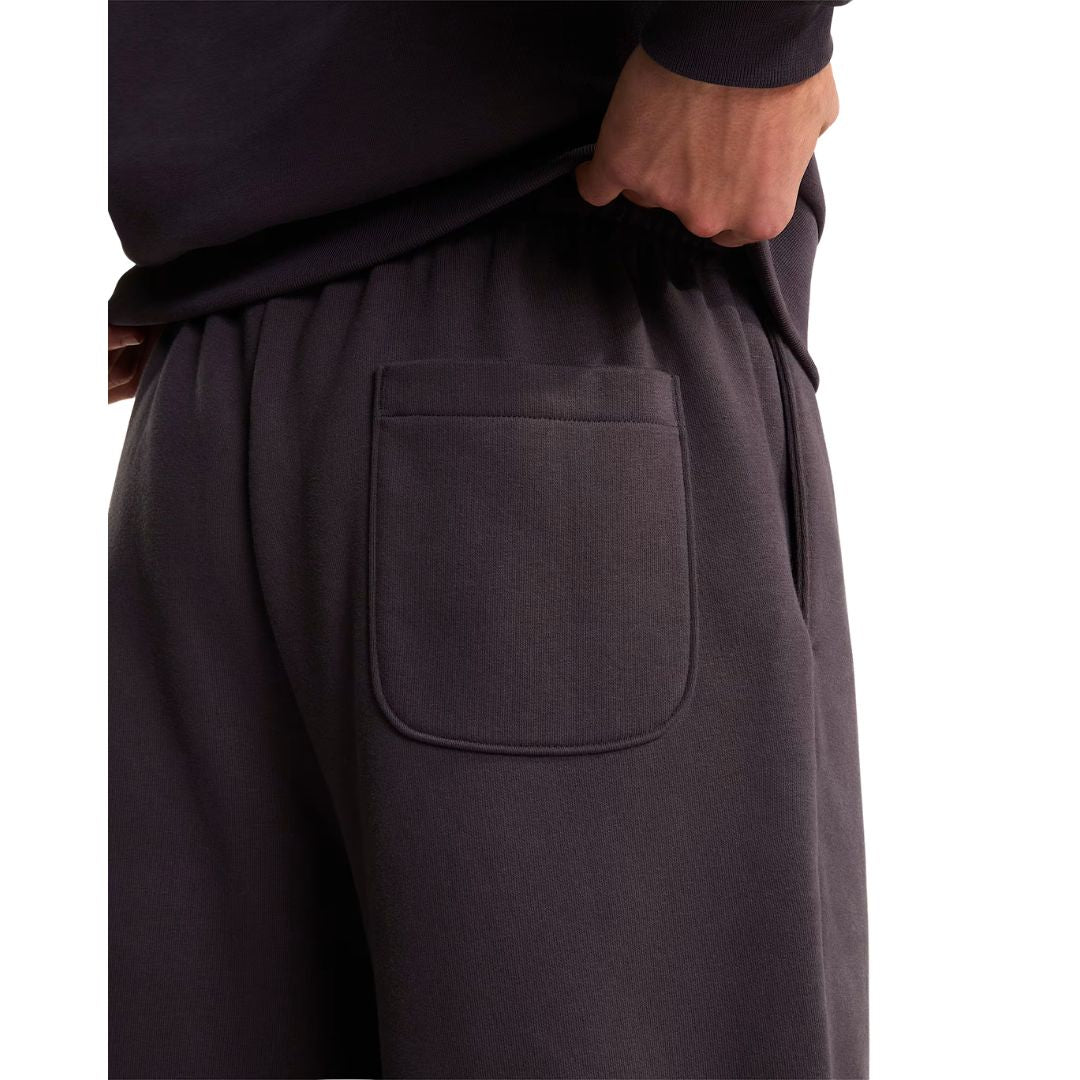 Detalle del bolsillo trasero de plastrón del pantalón de chándal Red Box de The North Face en color Obsidian, con acabado en algodón regenerativo y costuras reforzadas.