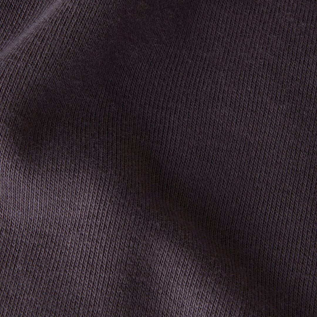 Detalle del tejido del pantalón de chándal Red Box de The North Face en color Obsidian, mostrando la textura afelpada del algodón regenerativo y poliéster reciclado de 430 g/m².