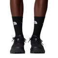 Calcetines The North Face Multi Sport Cushion en negro puestos en modelo con zapatillas de trail running negras, vista frontal mostrando el ajuste en el tobillo.