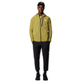 Modelo con chaqueta técnica The North Face en verde oliva, pantalón y gorra negros, look de estilo de vida asociado a la gama Multi Sport Cushion