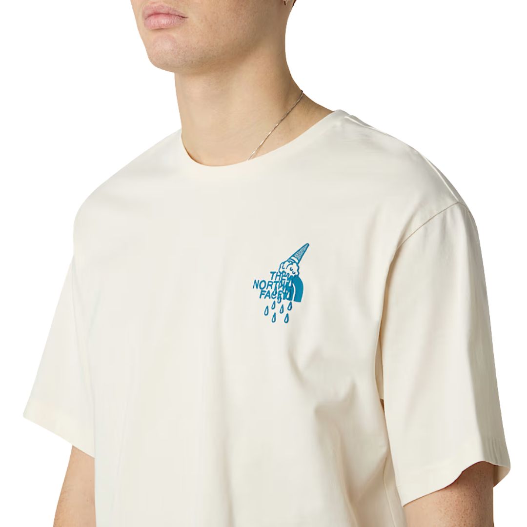 Detalle frontal camiseta The North Face Powder Days Relaxed White Dune con logo gráfico en el pecho en azul.