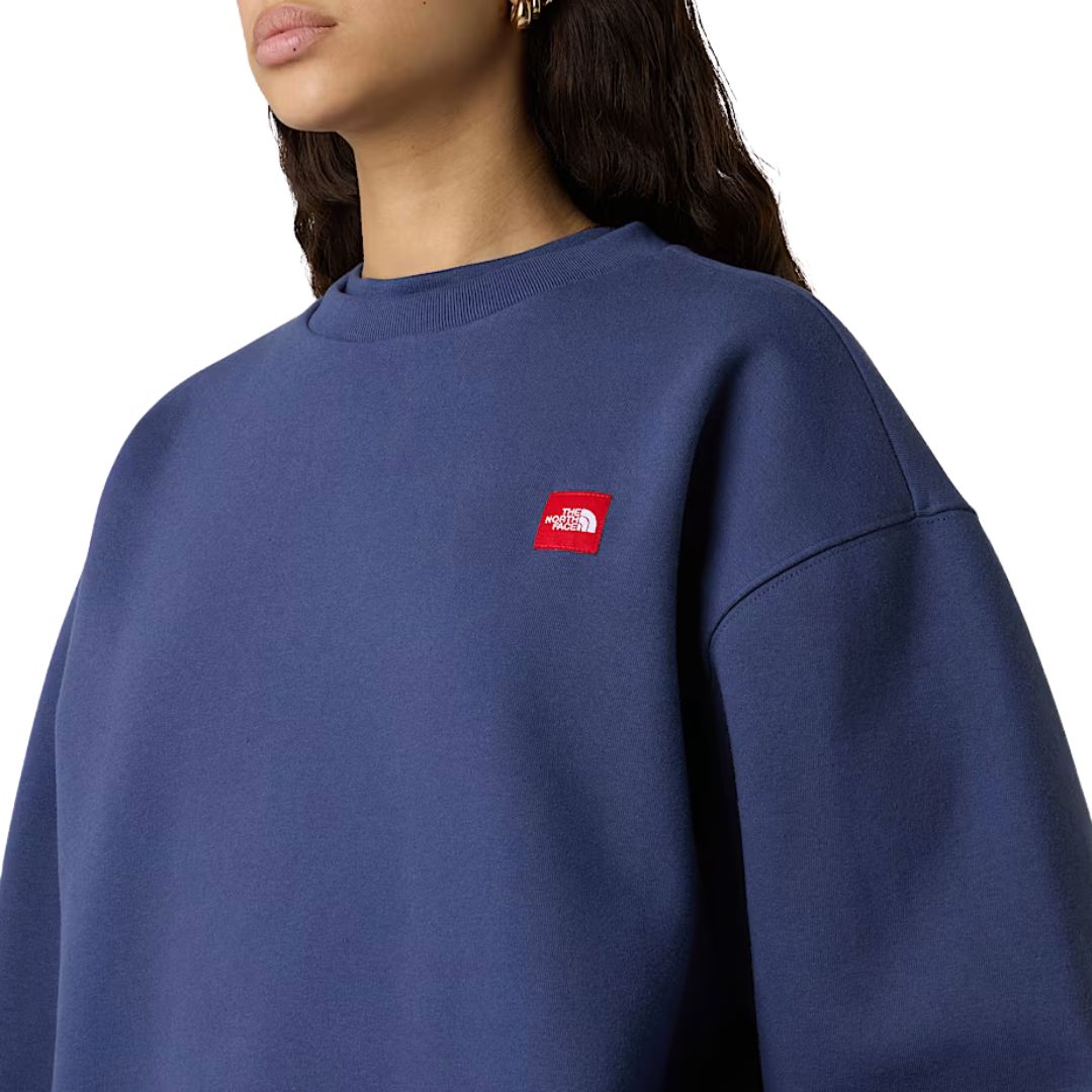 Detalle cercano del logotipo bordado en rojo de la sudadera THE NORTH FACE Red Box Crew Lunar Blue.