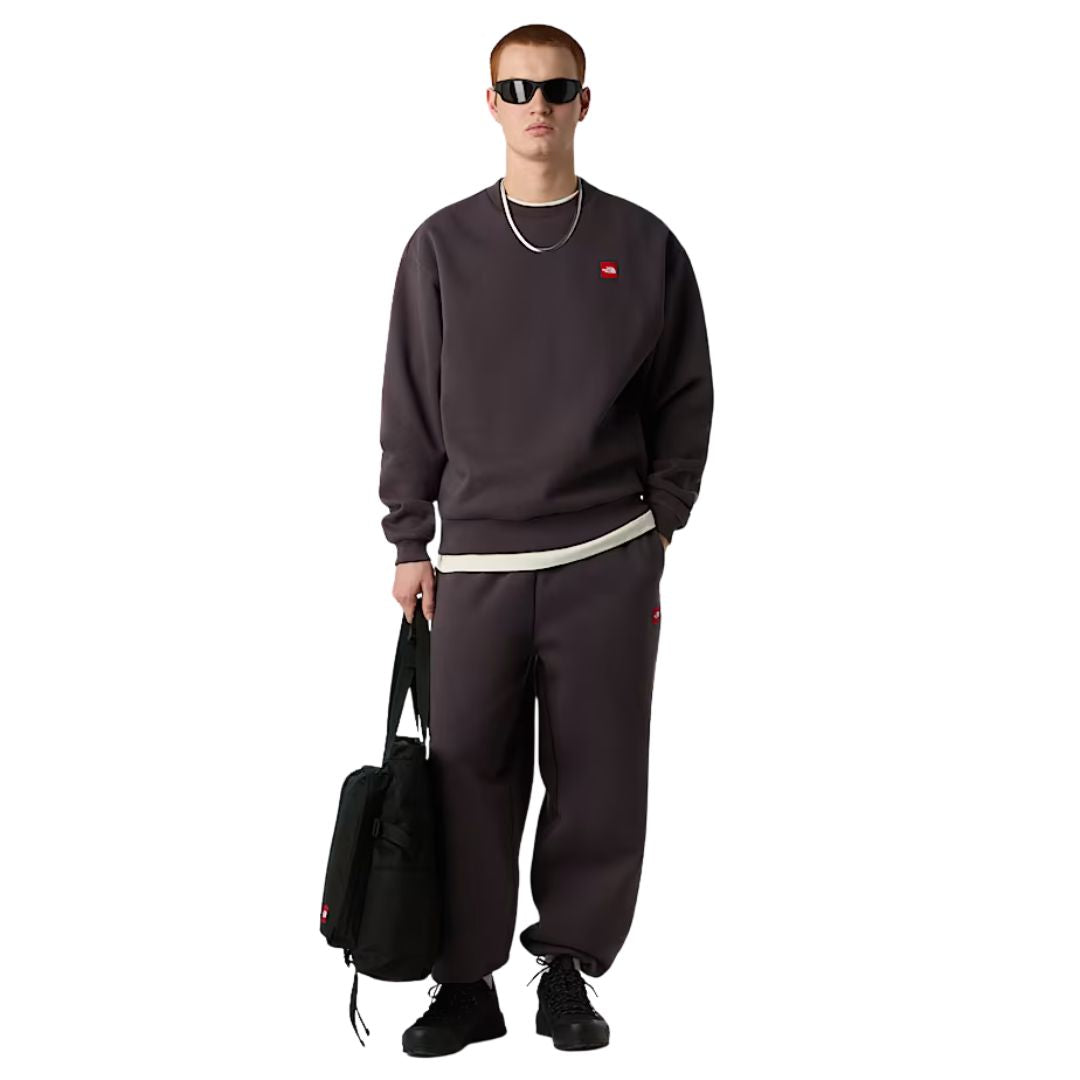 Vista de conjunto hombre vistiendo la sudadera The North Face Red Box Crew color Obsidian con pantalón a juego.