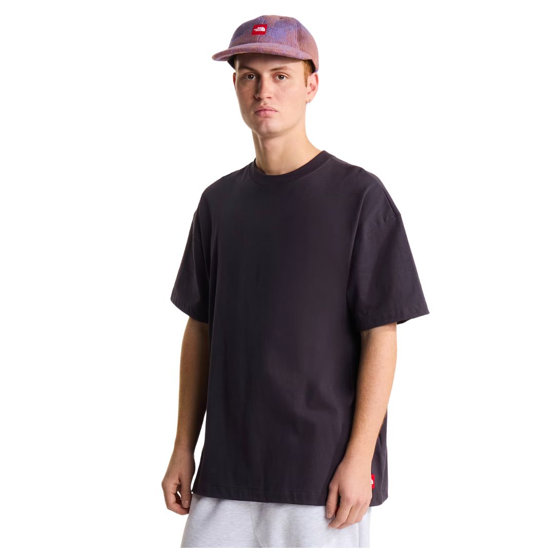 Camiseta The North Face Red Box oversize color obsidian, vista frontal de cuerpo entero sobre modelo con gorra, mostrando el pecho liso y el ajuste exagerado.