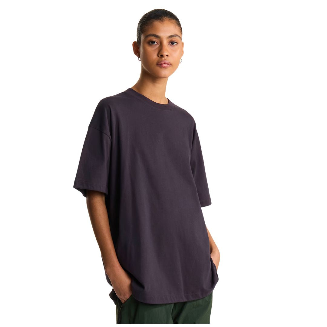 Camiseta The North Face Red Box oversize color obsidian, vista frontal de cuerpo entero sobre modelo con la mano en el bolsillo, mostrando el corte holgado y liso.