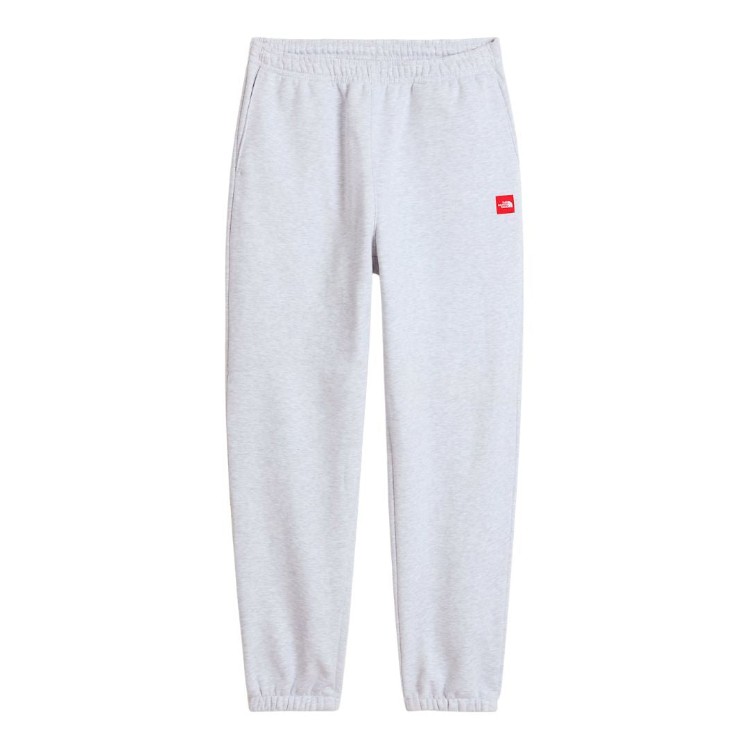 Pantalón de chándal The North Face Red Box en gris jaspeado TFN Classic en plano de producto, vista frontal con parche rojo del logo en la cadera y cordón de cintura visible.