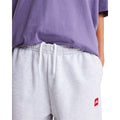 Detalle de la cintura elástica con cordón blanco del pantalón de chándal The North Face Red Box en gris jaspeado TFN Classic, junto al parche rojo del logo.