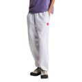 Pantalón de chándal The North Face Red Box en gris jaspeado TFN Classic, vista lateral de cuerpo completo con camiseta morada, bolsillo lateral y bajo con puño elástico ajustado.