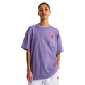 Camiseta The North Face Redbox manga corta unisex color Grounded Plum, mujer de pie con vista frontal mostrando el corte oversize y el parche bordado rojo.