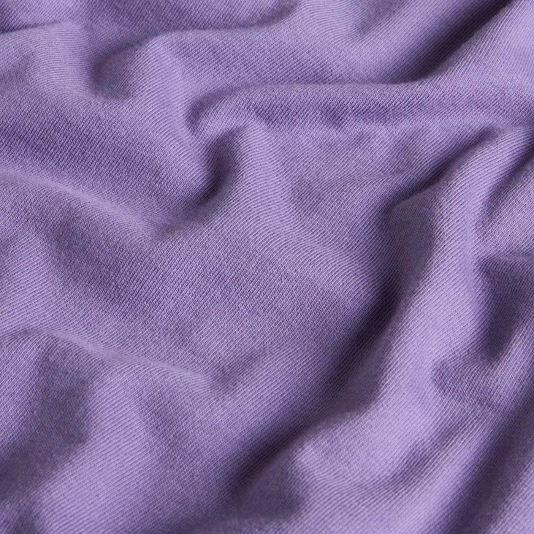Detalle del tejido de la camiseta The North Face Redbox unisex en color Grounded Plum, algodón regenerativo de 220 g/m² con textura suave de punto grueso.