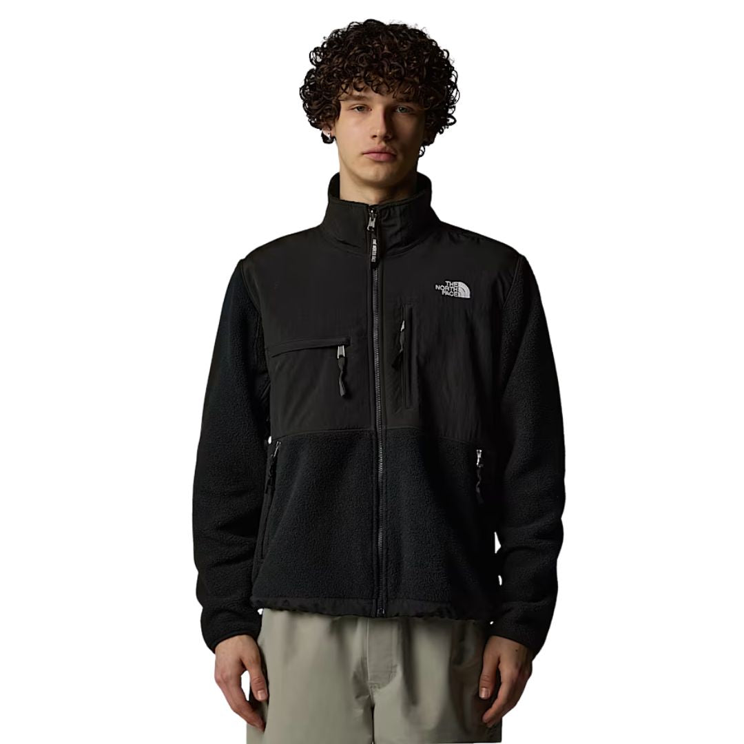 Hombre con la Chaqueta The North Face Retro Denali para hombre en color TFN Black con el logo en blanco, vista frontal completa con cremallera cerrada