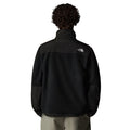 Hombre con la Chaqueta The North Face Retro Denali para hombre en color TFN Black con el logo en blanco, vista frontal completa con cremallera cerrada, vista posterior completa