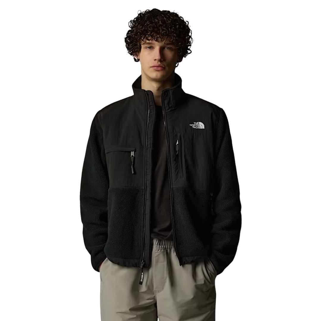 Hombre con la chaqueta Chaqueta The North Face Retro Denali para hombre en color TFN Black con el logo en blanco, vista frontal completa con cremallera abierta