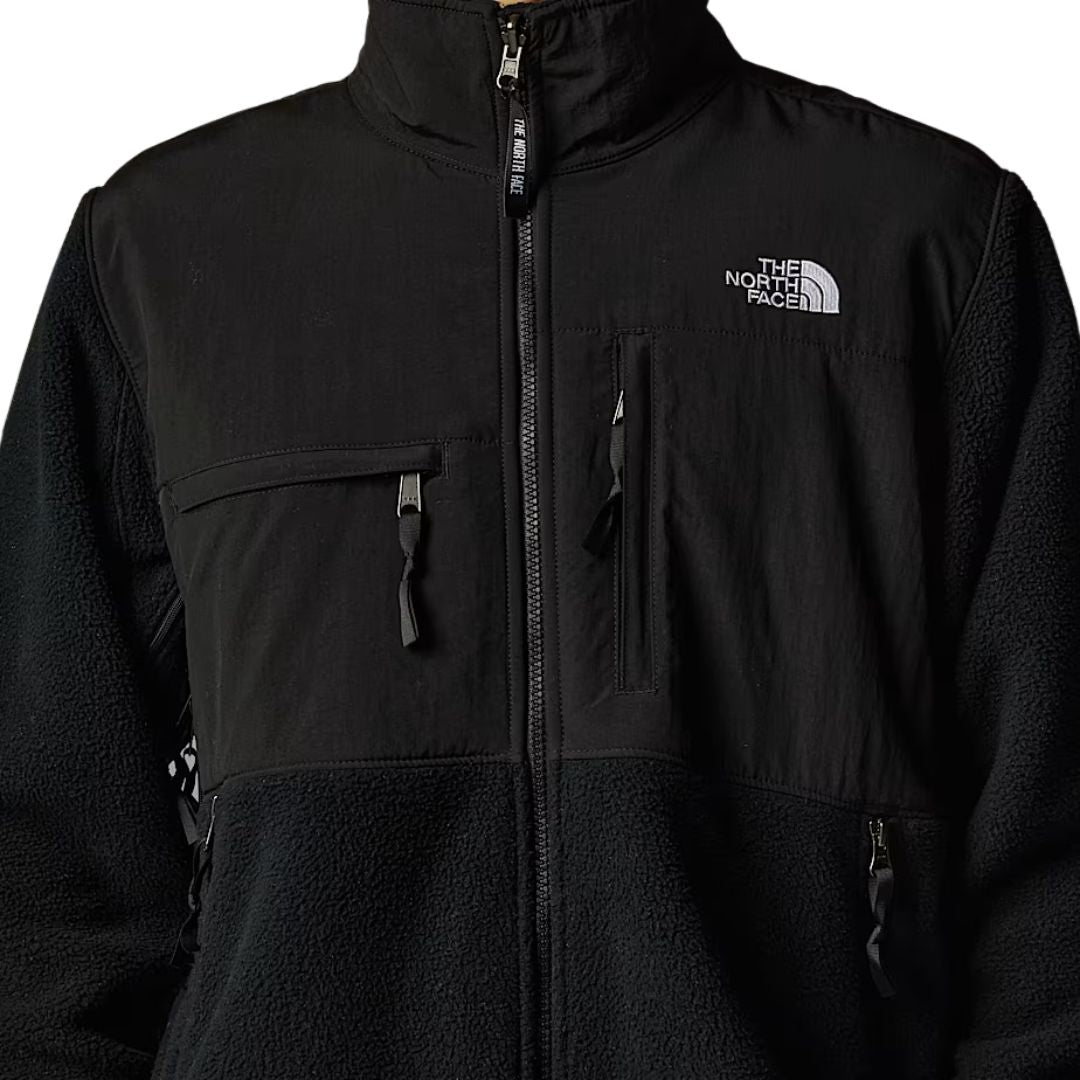 Primer plano del pecho de la chaqueta The North Face Retro Denali en TFN Black, con cremallera y logotipo bordado en blanco
