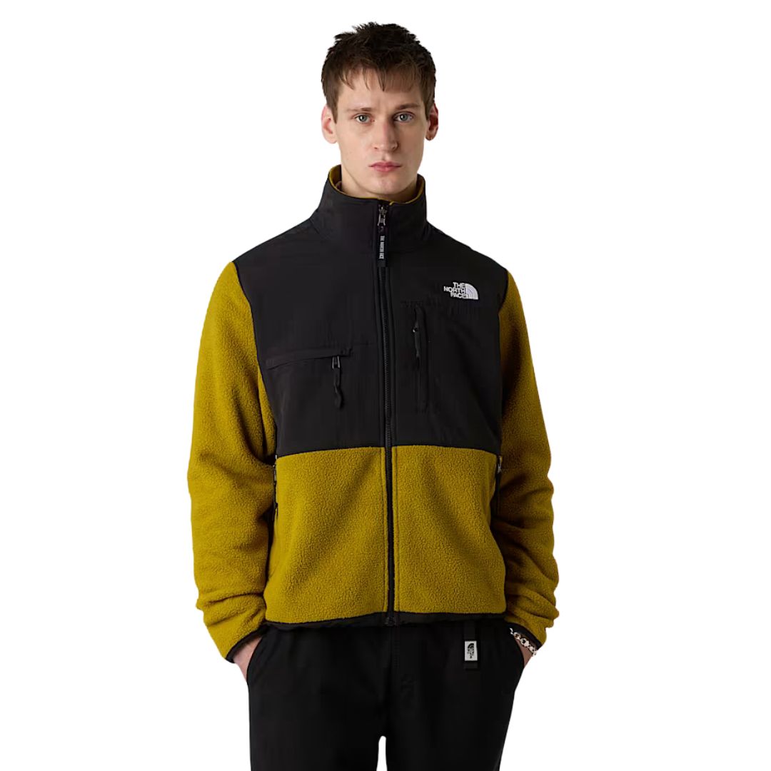 The North Face Retro Denali Jacket en mostaza Deep Dijon y negro, vista frontal con cremallera cerrada y cuello alto