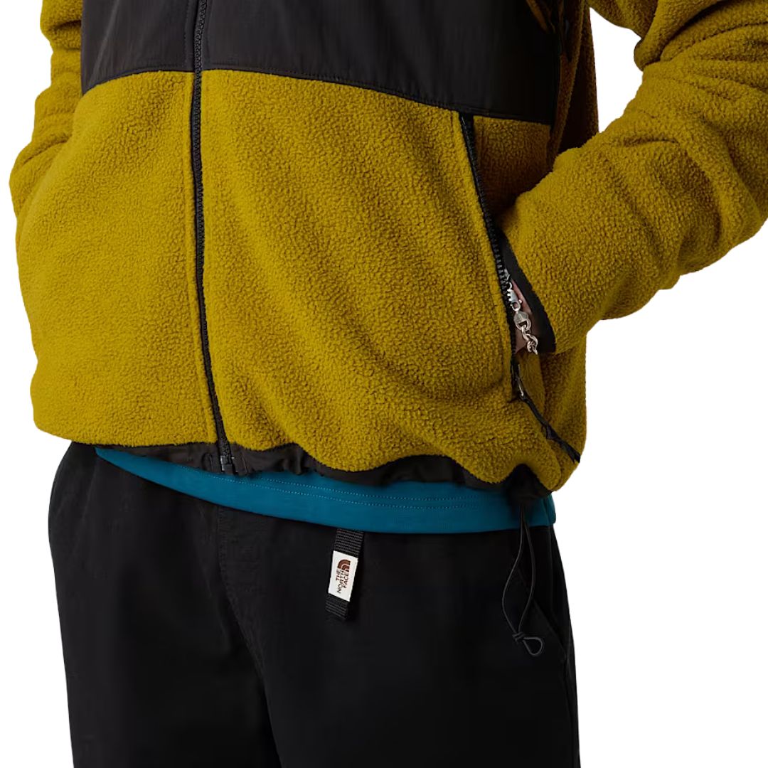 Detalle de los bolsillos con cremallera en la chaqueta Retro Denali de color mostaza con paneles negros