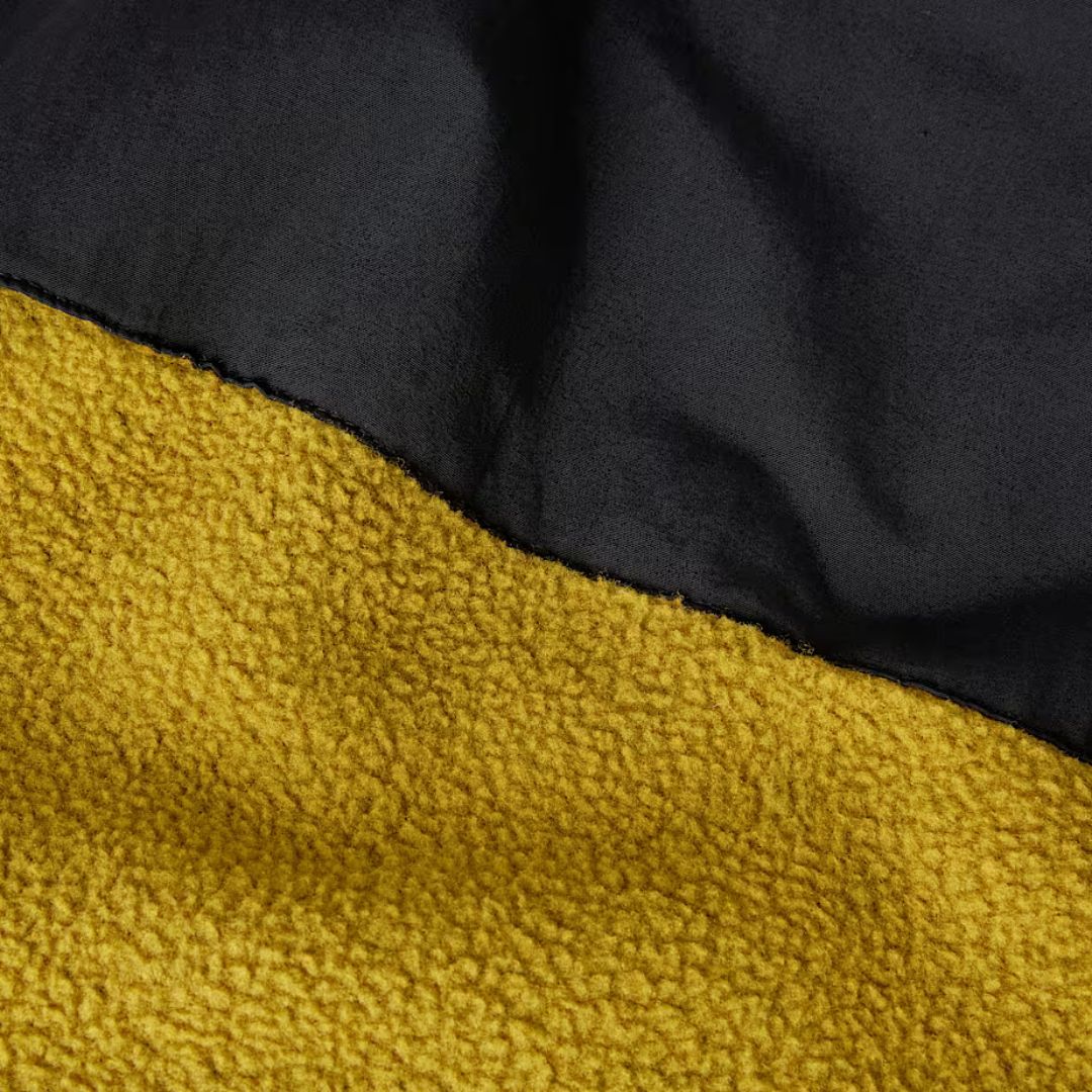 Detalle de tejido polar y técnico de la chaqueta Retro Denali en color Deep Dijon y negro