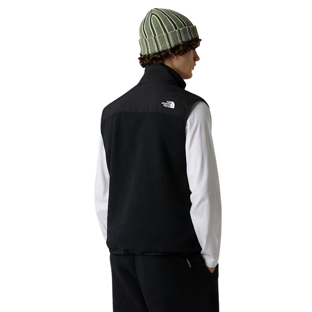 Modelo masculino con chaleco The North Face Retro Denali Vest en color negro, vista trasera.