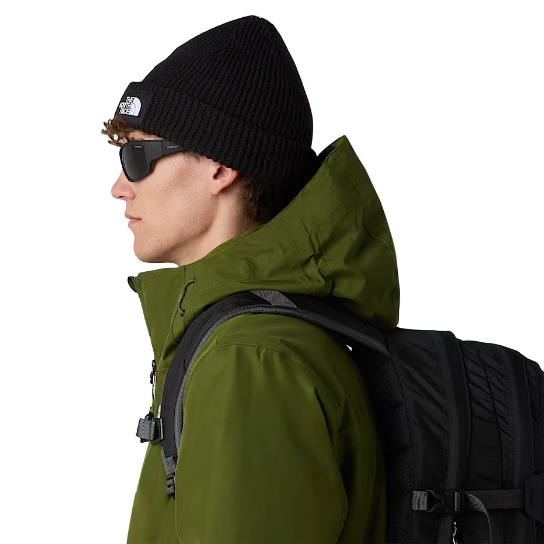 Modelo con gorro The North Face Salty Lined Beanie color negro TNF Black en estilo outdoor con chaqueta verde y mochila.