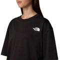 Camiseta The North Face SS NSE Oversized Tee en negro, modelo femenino mostrando el logotipo blanco en el pecho.