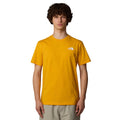 Hombre con la camiseta The North Face S/S Redbox Tee amarilla con el logo The North Face estampado en blanco en el pecho