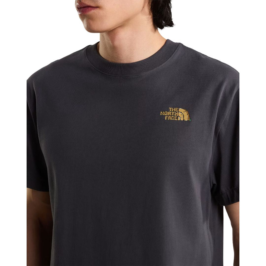 Primer plano del cuello y logotipo pequeño en el pecho de la camiseta The North Face Stone Logo RLX en gris antracita, con detalle del ribete del cuello redondo.