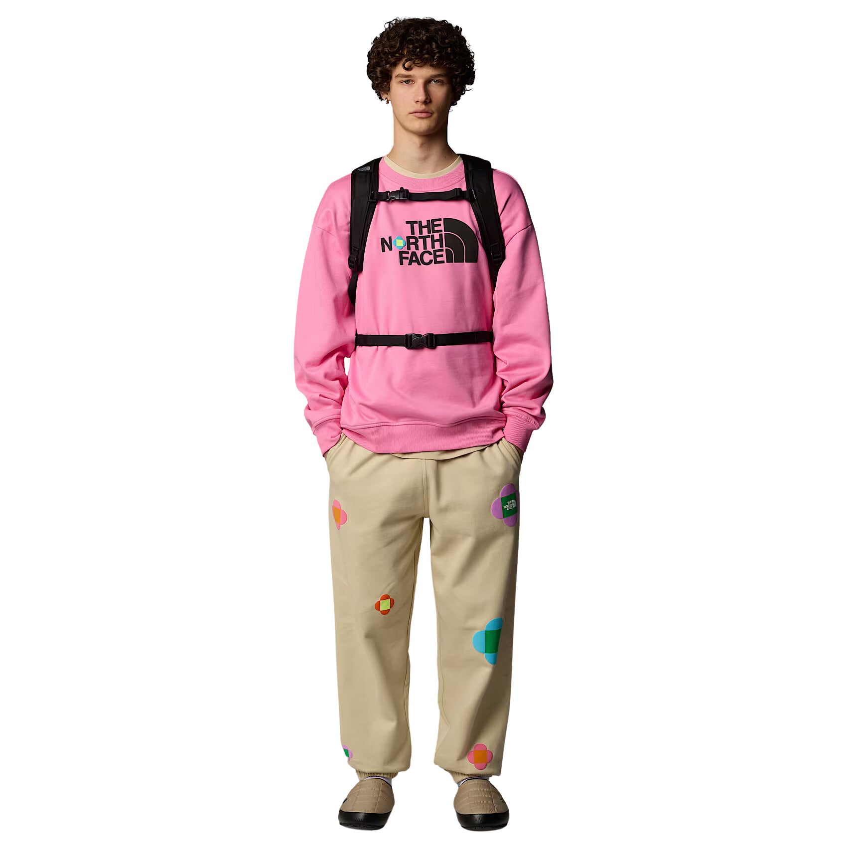 Hombre con la Sudadera The North Face TNF X Yinka Ilori Crew Gamma Pink con mochila