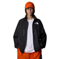 Mujer con la Chaqueta The North Face x Yinka Ilori Windshell Negra y gorra naranja abierta