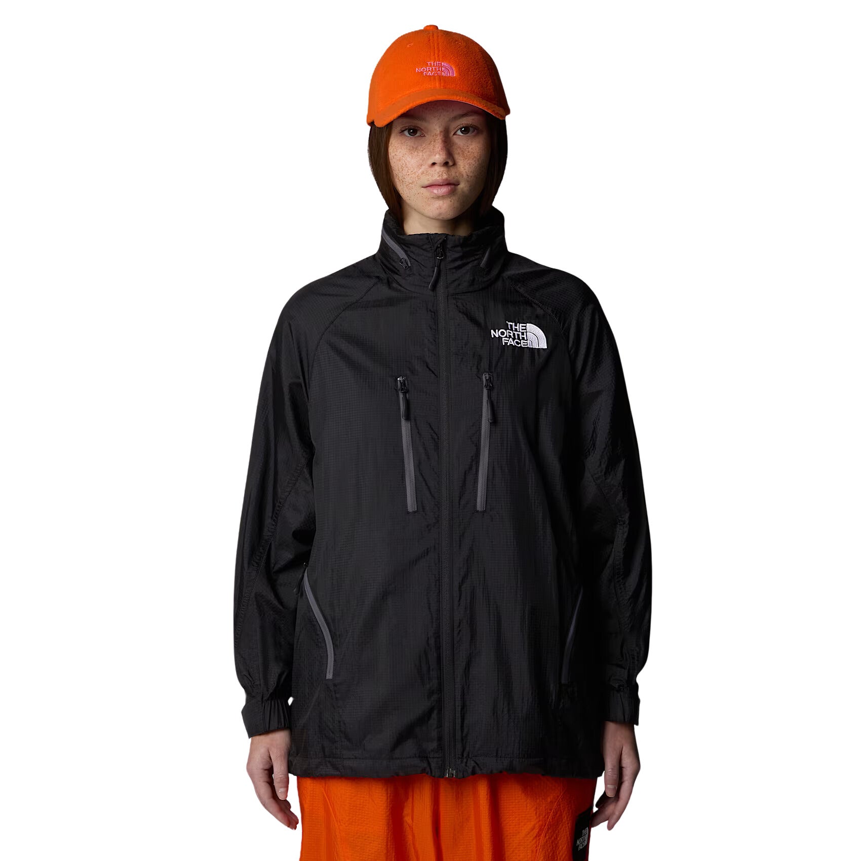 Mujer con la Chaqueta The North Face x Yinka Ilori Windshell Negra y gorra naranja