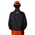 Hombre con la Chaqueta The North Face x Yinka Ilori Windshell Negra y gorra naranja espalda