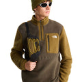 Modelo con la chaqueta polar The North Face Yumiori 1/4 Zip New Taupe Green/Caraway Seed y riñonera a juego, luciendo el bolsillo delantero con logotipo de la marca.