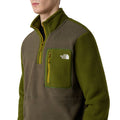 Modelo vistiendo la chaqueta The North Face Yumiori 1/4 Zip en color New Taupe Green, vista en ángulo lateral.