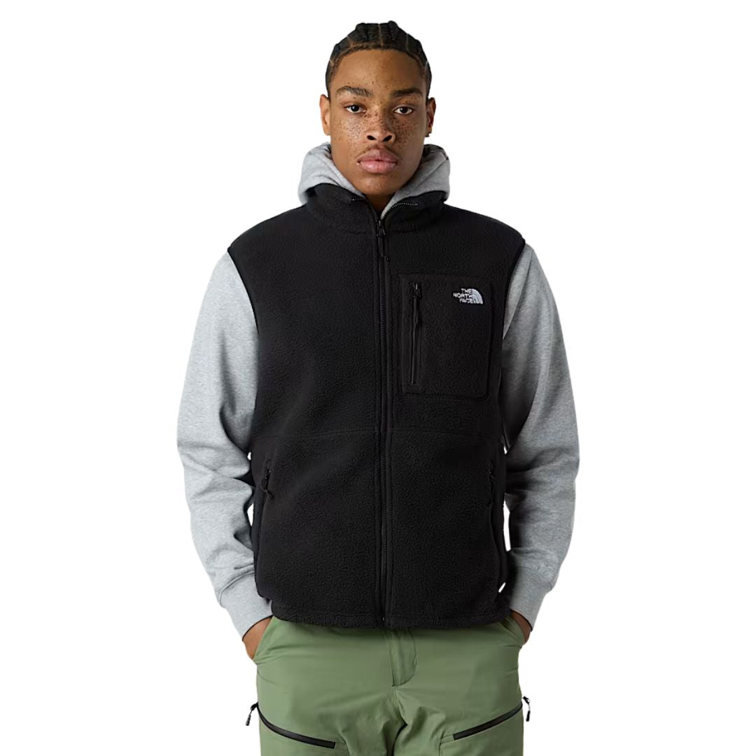 Modelo vistiendo el chaleco The North Face Yumiori Vest negro sobre sudadera con capucha gris.