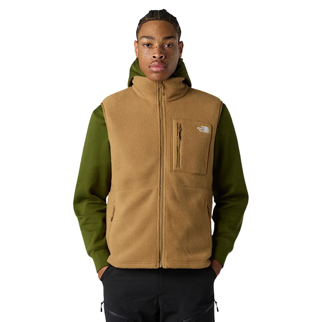 Modelo de pie vistiendo chaleco polar The North Face Yumiori Vest color Utility Brown, vista frontal cerrada.