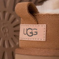 Detalle del talón con logotipo UGG en piel de las botas Classic Micro color Chestnut.