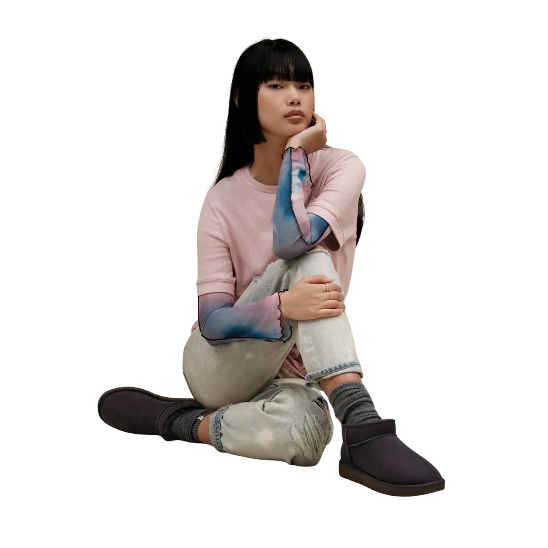 Modelo vistiendo botas UGG Classic Ultra Mini color Black combinadas con outfit urbano casual.