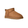 Vista en ángulo de tres cuartos de la bota UGG Classic Ultra Mini en color chestnut, con la puntera redondeada, la textura aterciopelada y la suela EVA antideslizante.